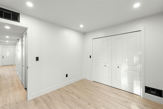 unfurnished bedroom featuring a closet and light hardwood / wood-style floors