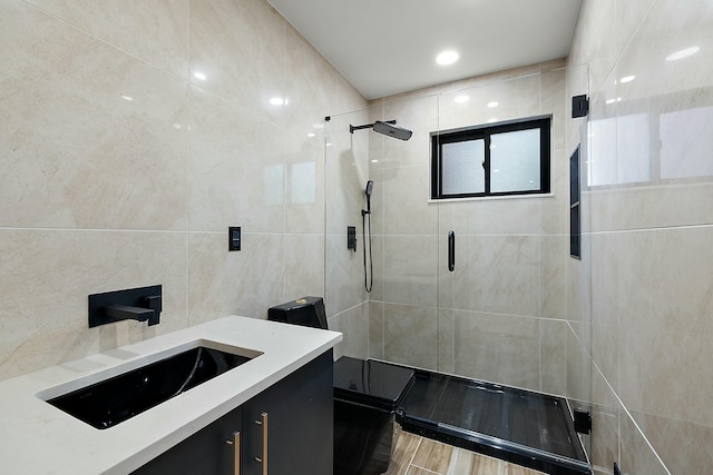 bathroom with vanity, walk in shower, and tile walls