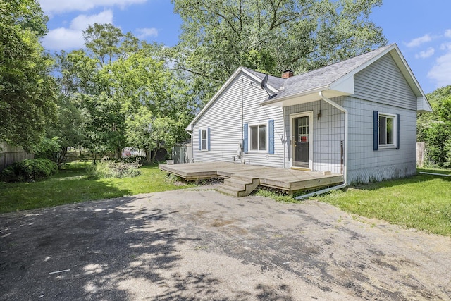 back of house featuring a lawn and a deck