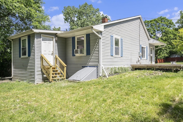 view of front of home featuring a front lawn, cooling unit, and a wooden deck