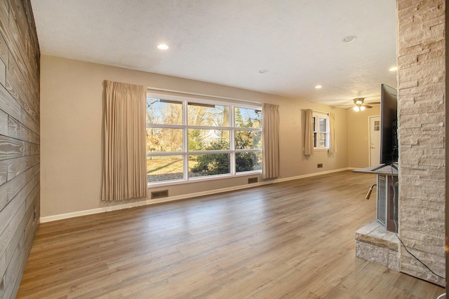 unfurnished living room featuring hardwood / wood-style floors, a textured ceiling, and ceiling fan