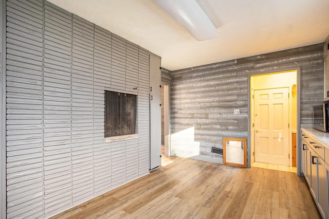 unfurnished living room with log walls and light hardwood / wood-style floors