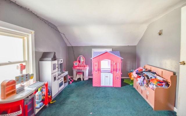 recreation room featuring dark carpet and lofted ceiling