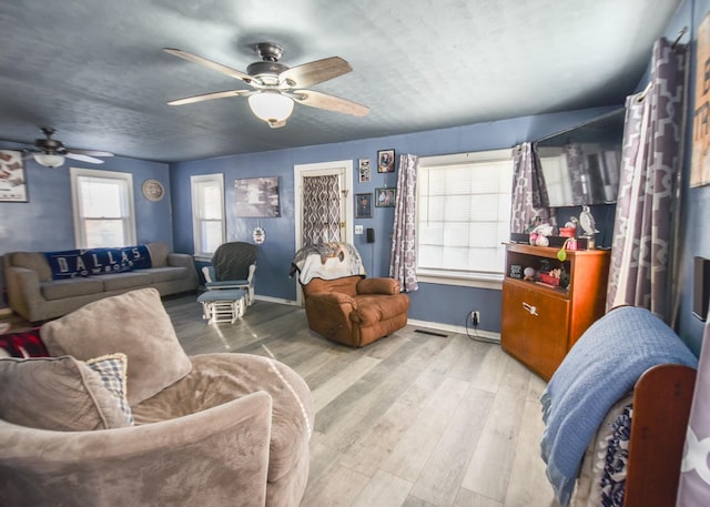 living room with ceiling fan and light wood-type flooring