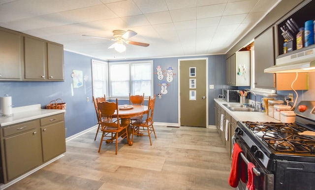 kitchen featuring crown molding, sink, light hardwood / wood-style flooring, gas range, and ceiling fan