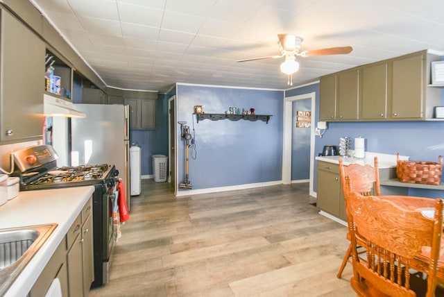 kitchen featuring stainless steel range with gas cooktop, sink, light hardwood / wood-style flooring, ceiling fan, and extractor fan