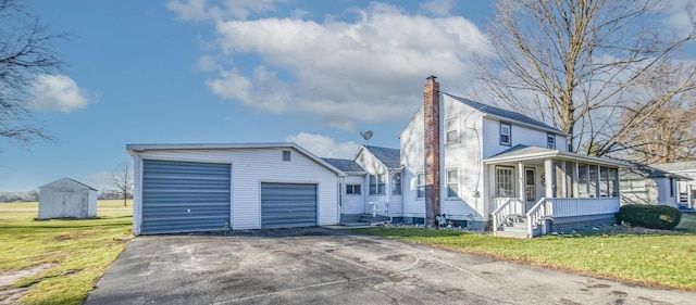 view of front of property with a storage shed and a front lawn