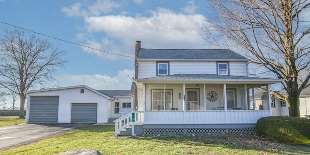 view of front of house with an outbuilding, a garage, a front lawn, and covered porch