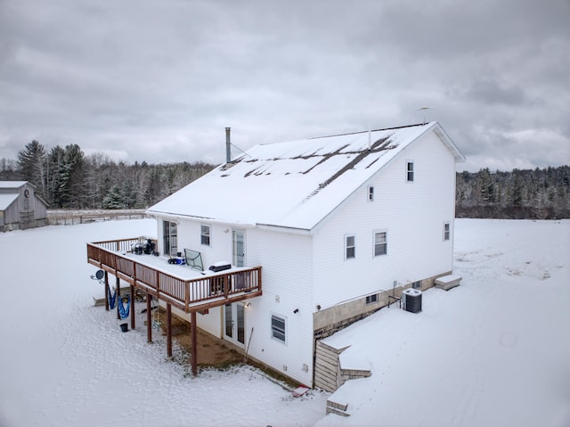 snow covered property featuring central AC