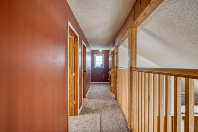 hall featuring light carpet and a textured ceiling