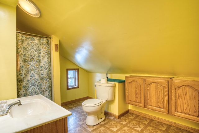 bathroom with vanity, toilet, and vaulted ceiling