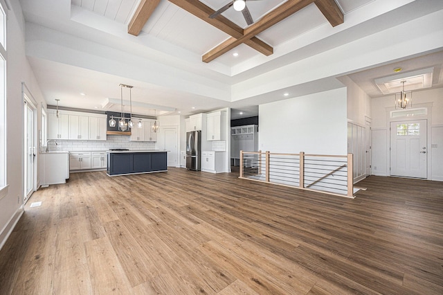 3545 Conrail Dr, Byron Center, MI 49315 - unfurnished living room with wood finished floors, beamed ceiling, recessed lighting, ceiling fan, and a sink