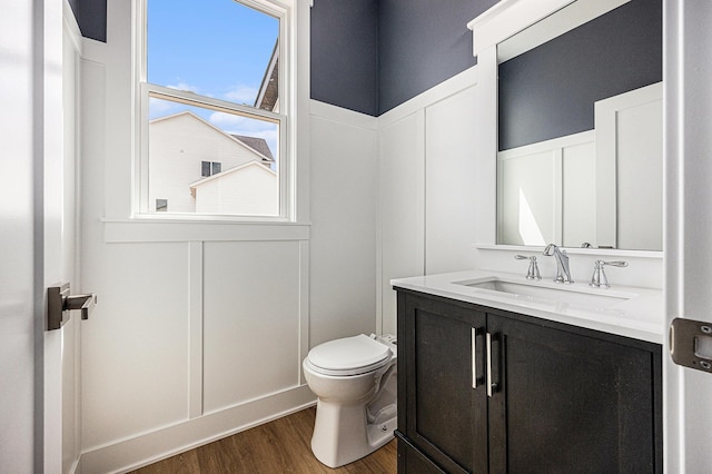 3545 Conrail Dr, Byron Center, MI 49315 - bathroom with vanity, wood finished floors, toilet, a decorative wall, and a wainscoted wall