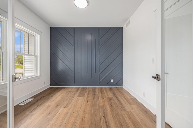 3545 Conrail Dr, Byron Center, MI 49315 - unfurnished bedroom featuring light wood finished floors, baseboards, and an accent wall