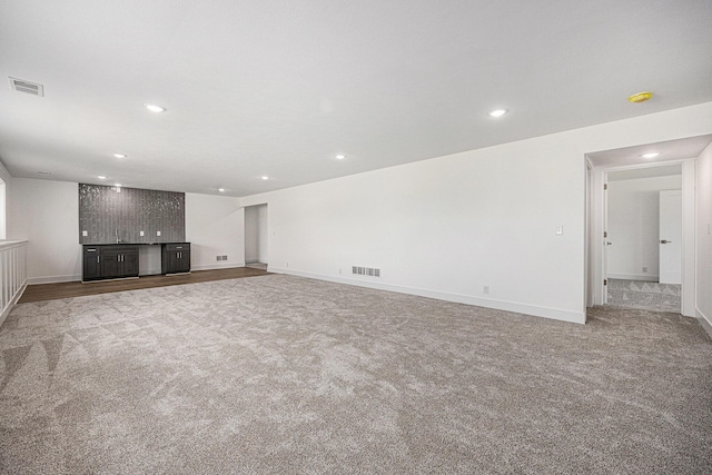 3545 Conrail Dr, Byron Center, MI 49315 - unfurnished living room featuring carpet flooring, bar with sink, recessed lighting, and baseboards