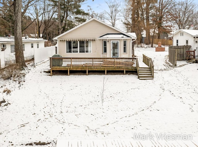 snow covered house with a deck