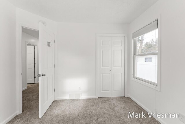 unfurnished bedroom with carpet and a closet