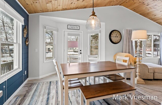 dining space featuring light wood-type flooring, lofted ceiling, and wood ceiling