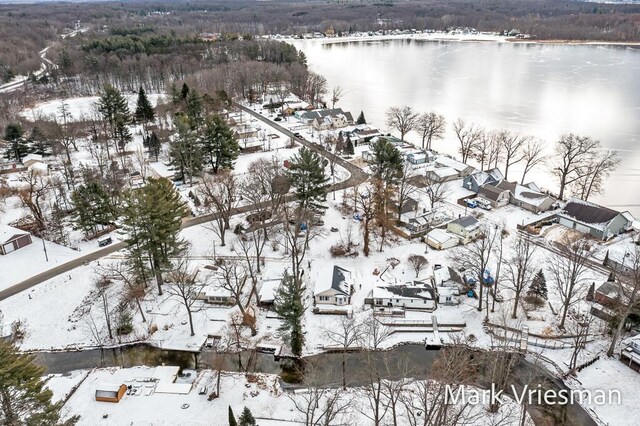 snowy aerial view with a water view