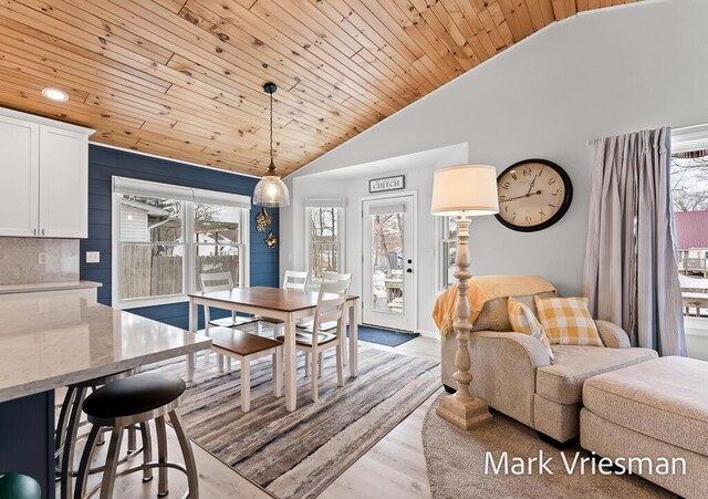 dining space featuring a healthy amount of sunlight, wooden ceiling, lofted ceiling, and light wood-type flooring