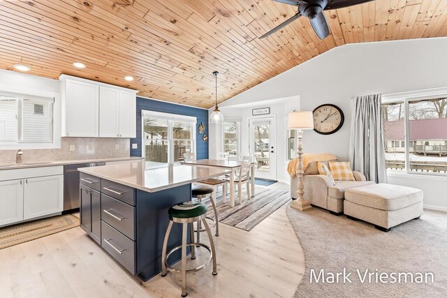 kitchen featuring white cabinets, pendant lighting, backsplash, and dishwasher