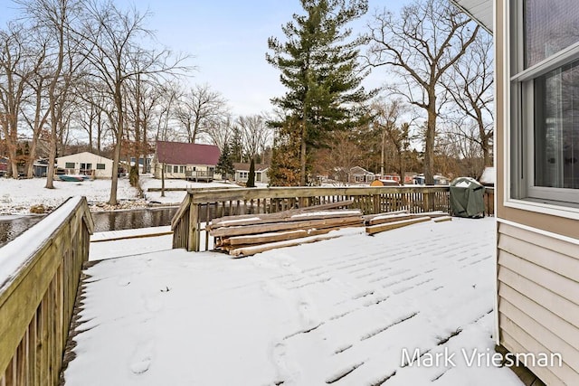 snow covered deck with a grill