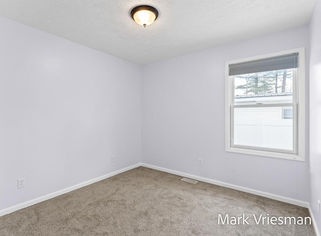 carpeted spare room featuring a textured ceiling