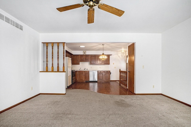 unfurnished living room featuring sink, ceiling fan with notable chandelier, and dark colored carpet