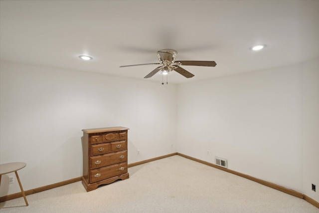 spare room featuring light colored carpet and ceiling fan