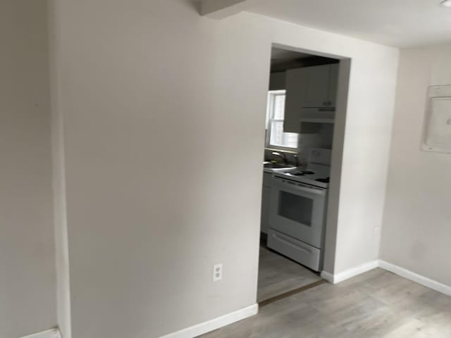 kitchen with white range, light hardwood / wood-style flooring, extractor fan, and sink