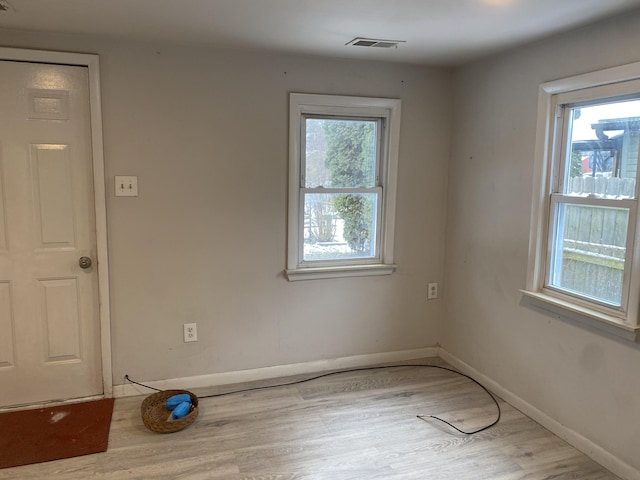 unfurnished room featuring light hardwood / wood-style flooring and a healthy amount of sunlight