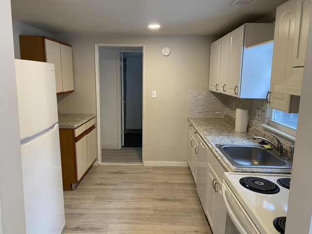 kitchen featuring white cabinetry, sink, backsplash, white appliances, and light wood-type flooring