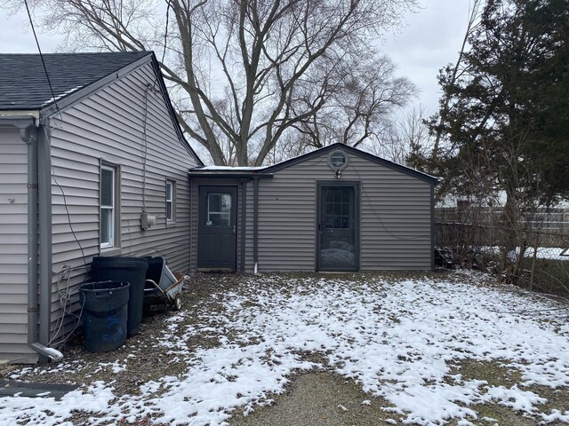 view of snow covered rear of property