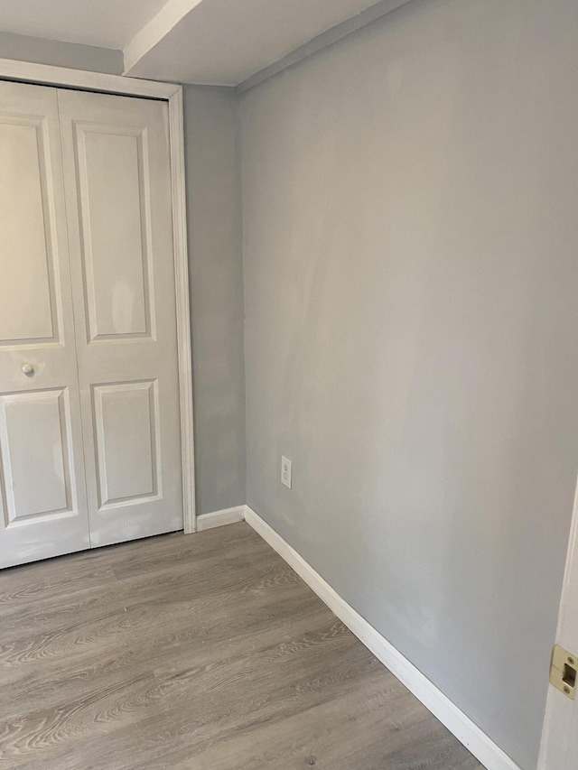 unfurnished bedroom with light wood-type flooring and a closet