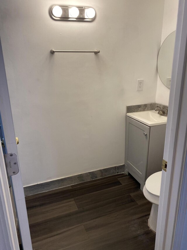 bathroom featuring vanity, toilet, and wood-type flooring