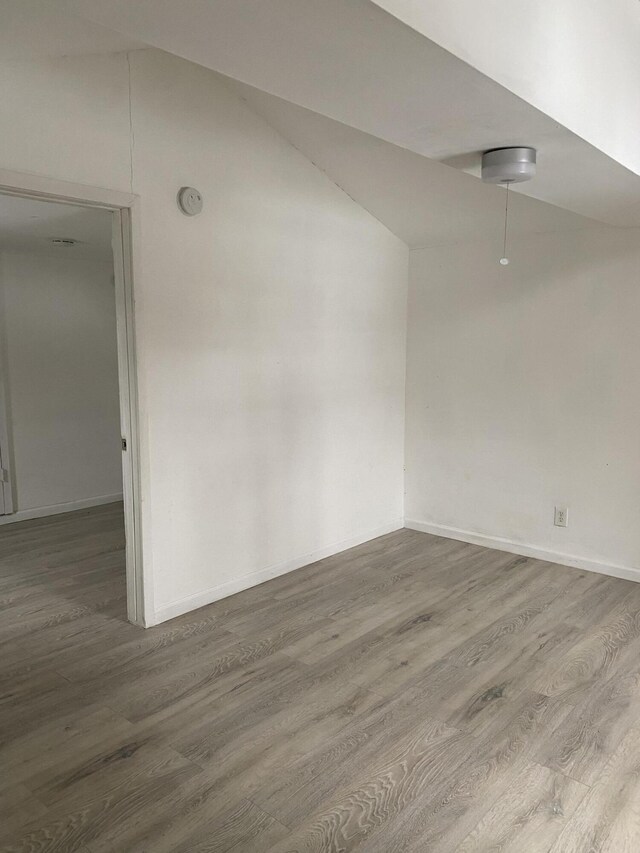 unfurnished room featuring hardwood / wood-style floors and lofted ceiling