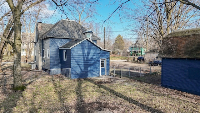 view of property exterior with central AC unit and a yard