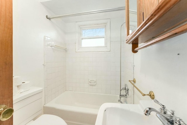 full bathroom with tiled shower / bath combo, toilet, and sink