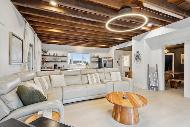 living room featuring beam ceiling and light wood-type flooring