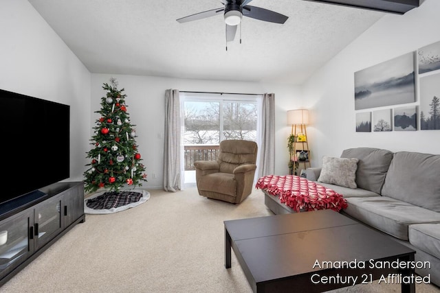 carpeted living room featuring vaulted ceiling with beams, ceiling fan, and a textured ceiling