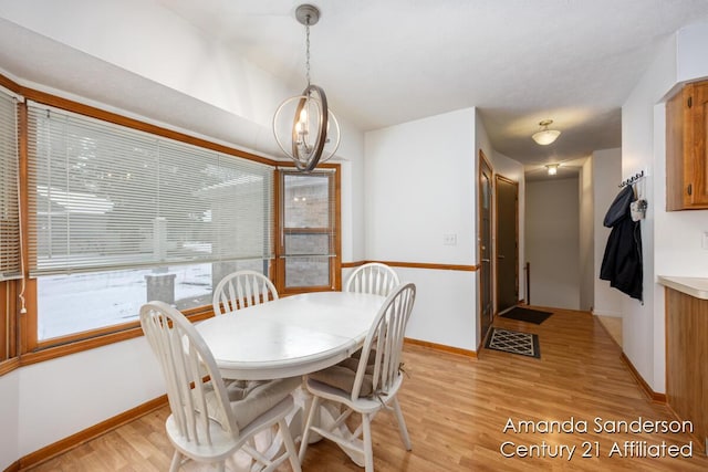 dining area featuring light wood-type flooring and a notable chandelier