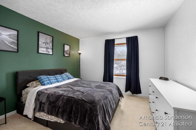 bedroom featuring light colored carpet and a textured ceiling