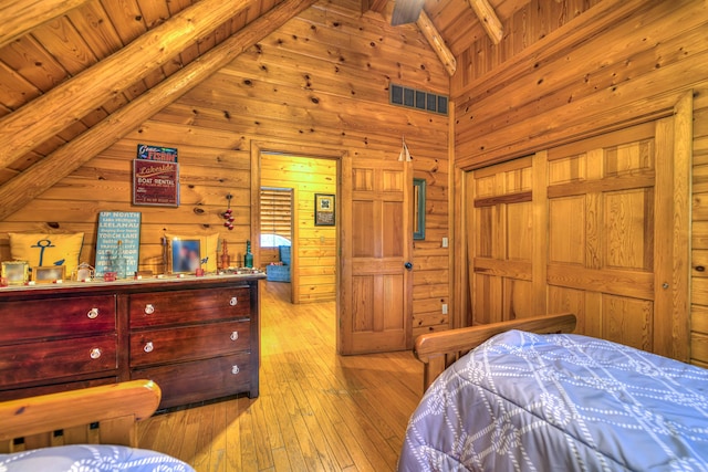 bedroom with beamed ceiling, light wood-type flooring, wood ceiling, and high vaulted ceiling