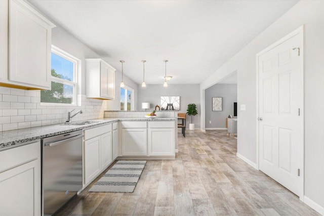 kitchen with kitchen peninsula, white cabinets, stainless steel dishwasher, and hanging light fixtures