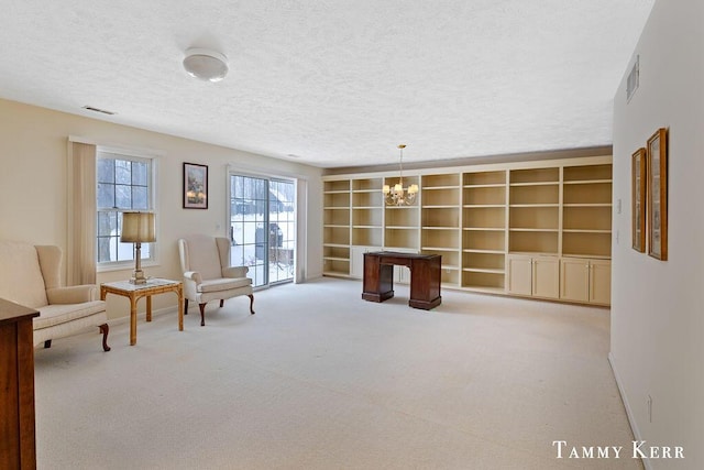 living area with built in features, light colored carpet, a textured ceiling, and a notable chandelier