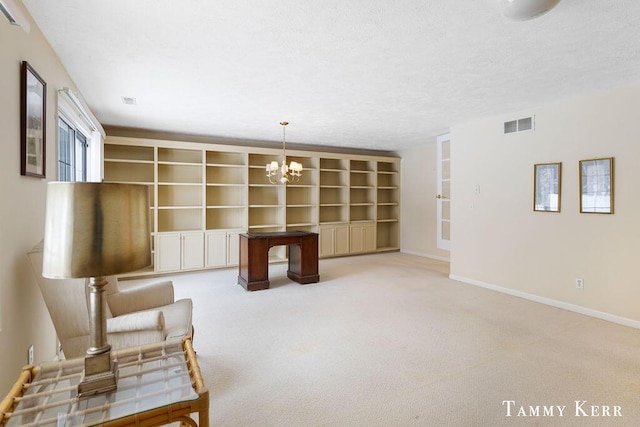 sitting room featuring light carpet, a textured ceiling, an inviting chandelier, and built in features