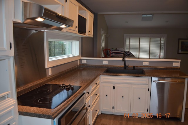 kitchen featuring white cabinetry, stainless steel appliances, sink, dark hardwood / wood-style floors, and kitchen peninsula