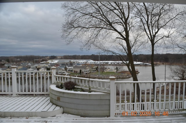 snow covered deck featuring a water view