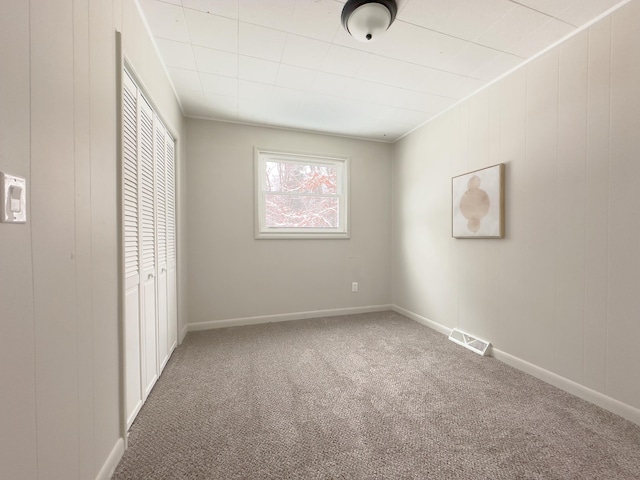 unfurnished bedroom featuring a closet, crown molding, and carpet flooring