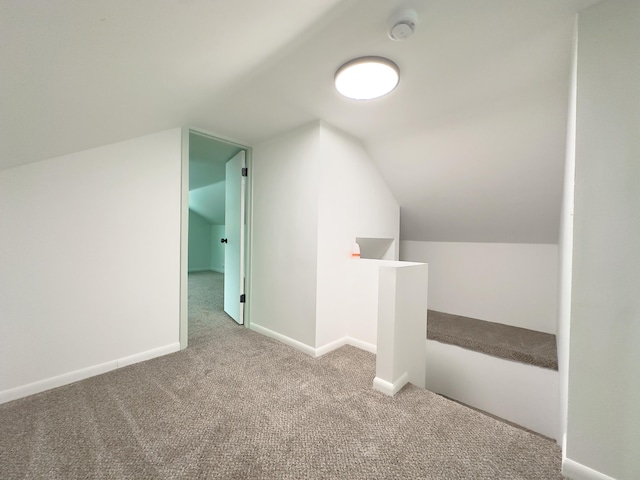 bonus room with carpet floors and vaulted ceiling